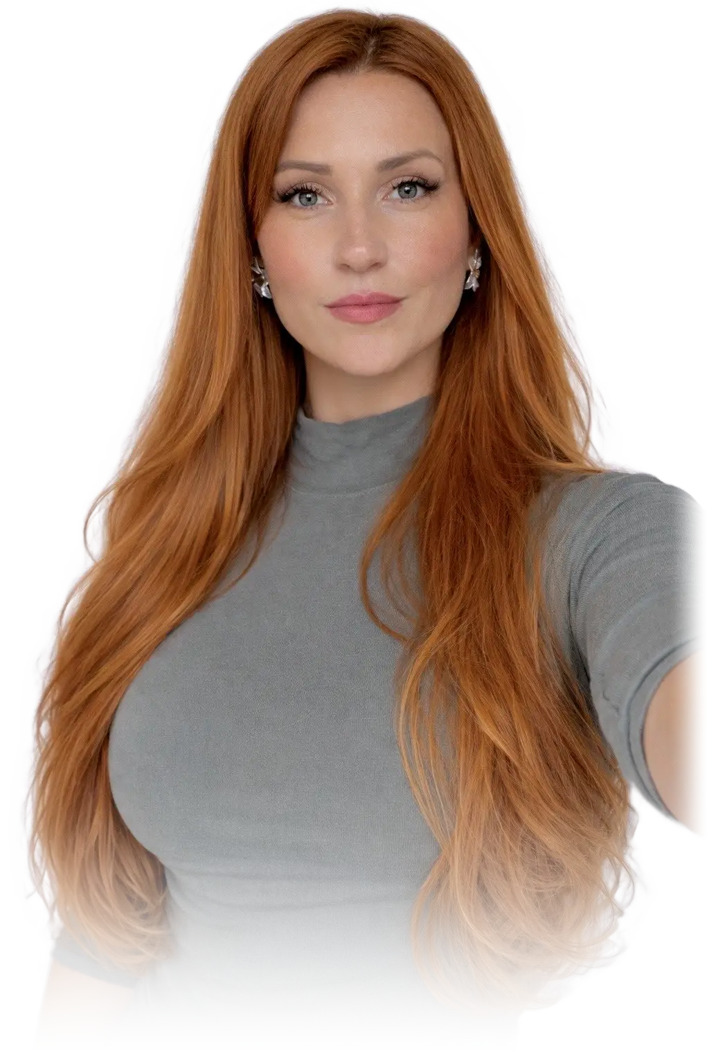 Milica, long copper hair falling past her shoulders, in a grey high-necked top, looking directly at the camera.