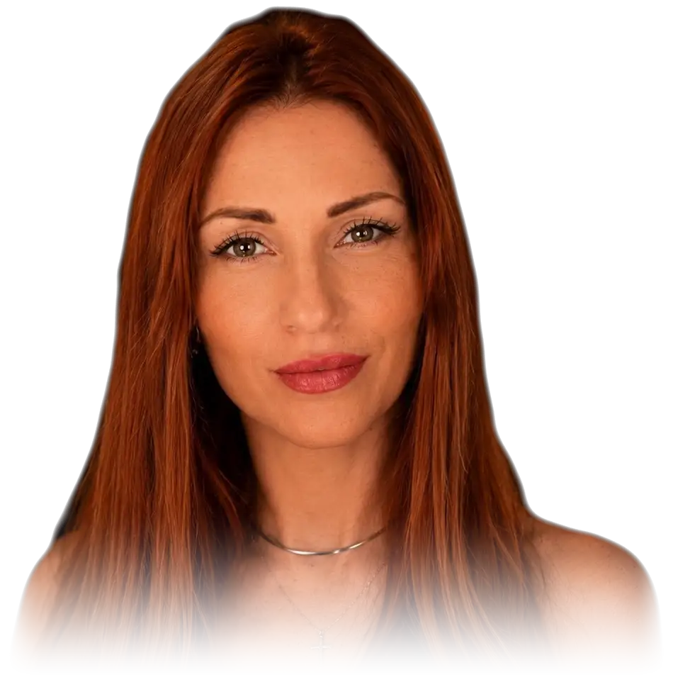 Milica, head and shoulders against a plain ground, long auburn hair falling either side of her face, a fine chain at her throat, facing the camera in an even light.